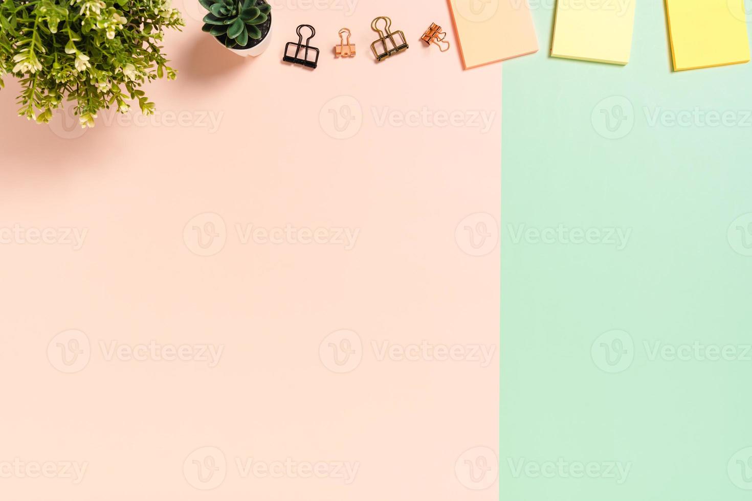 spazio di lavoro minimo - foto creativa piatta della scrivania dell'area di lavoro. scrivania da ufficio vista dall'alto con nota adesiva su sfondo di colore rosa verde pastello. vista dall'alto con spazio di copia, fotografia piatta.