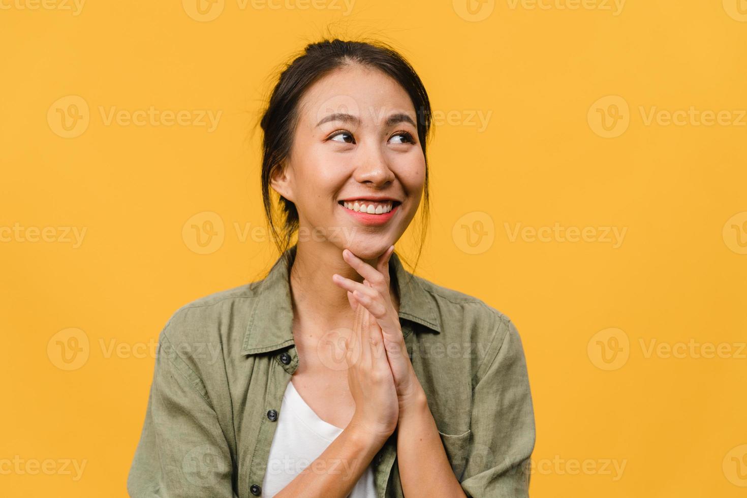 ritratto di giovane donna asiatica con espressione positiva, sorriso ampiamente, vestita con abiti casual su sfondo giallo. felice adorabile donna felice esulta successo. concetto di espressione facciale. foto