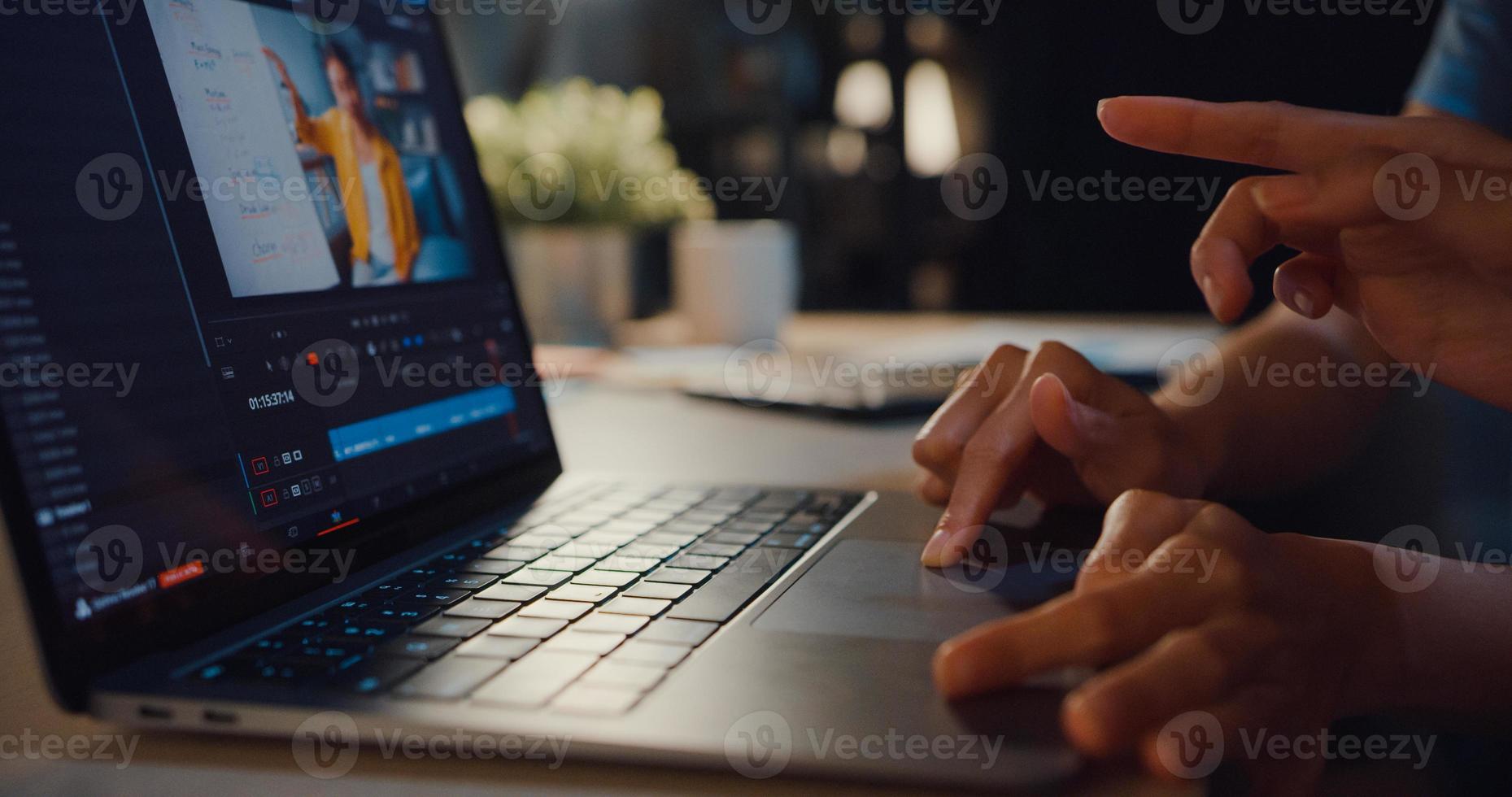 giovani donne blogger asiatiche che guardano filmati sul laptop condividendo idee con un amico e lavorando sull'editing video sul computer facendo il montaggio e la correzione del colore nel soggiorno di casa di notte. foto