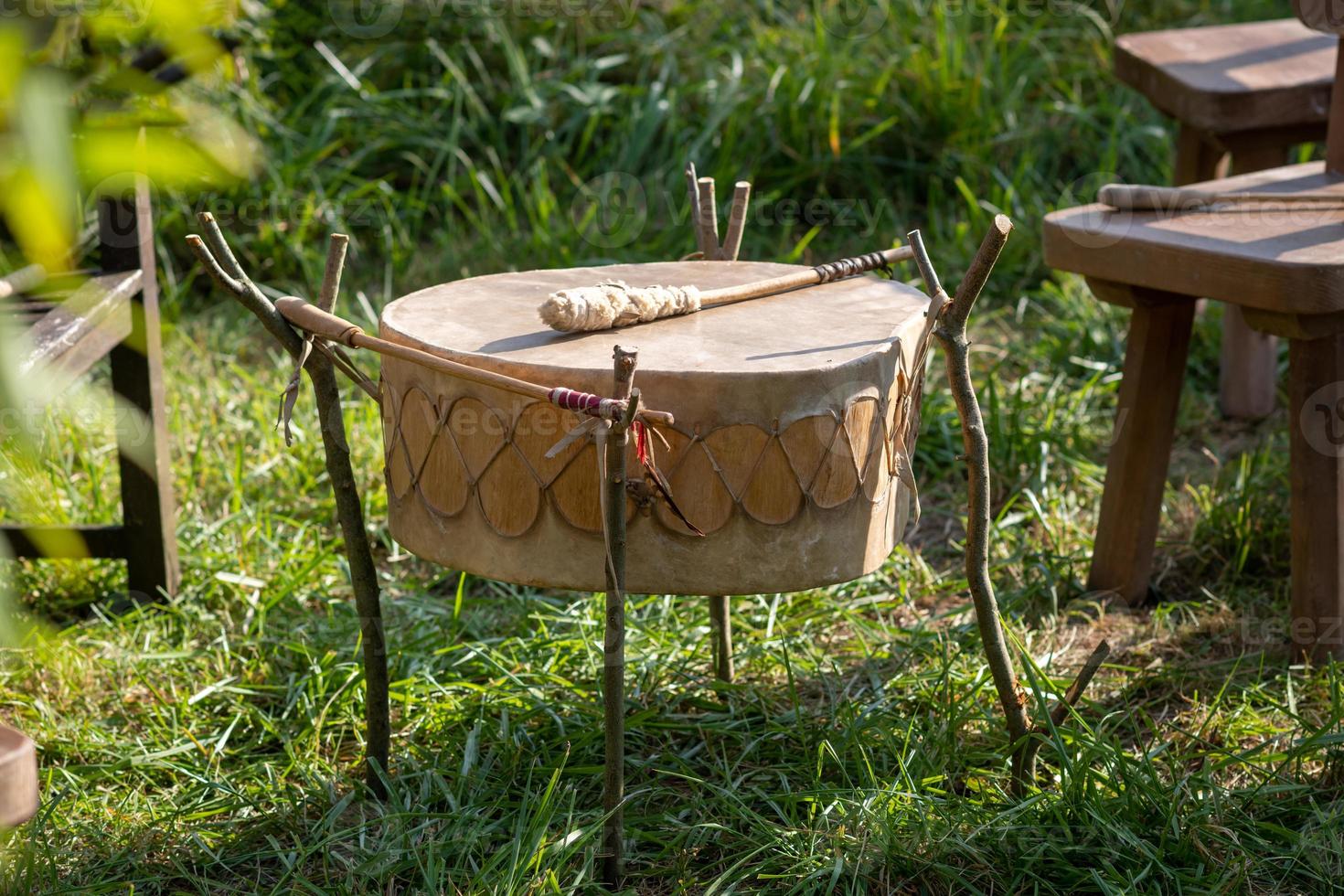 tamburo indiano nordamericano fatto di rawhide con pipistrello pronto per suonare foto