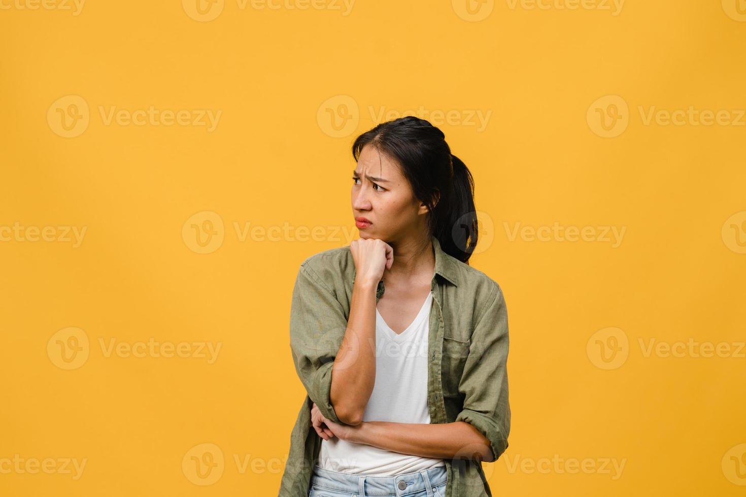 ritratto di giovane donna asiatica con espressione negativa, urla eccitata, pianto emotivo arrabbiato in abbigliamento casual isolato su sfondo giallo con spazio vuoto per la copia. concetto di espressione facciale. foto