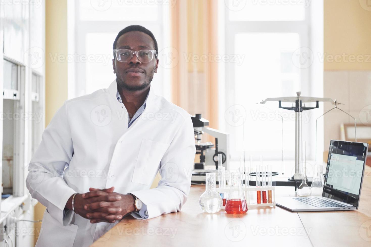 un lavoratore afroamericano lavora in un laboratorio conducendo esperimenti. foto