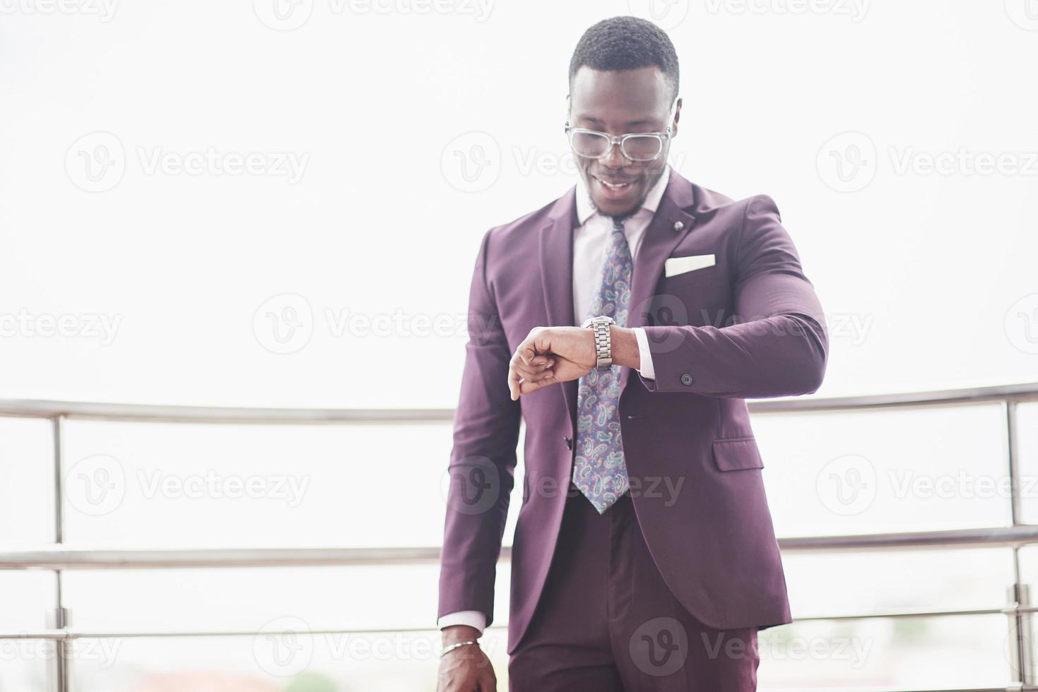 un bellissimo uomo d'affari afroamericano legge in un caffè foto