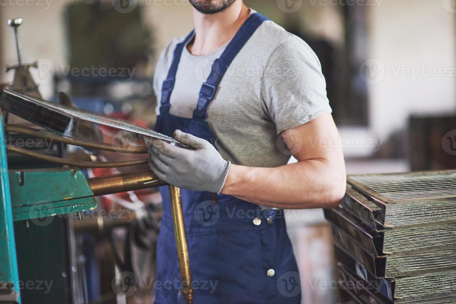 ritratto di un giovane maestro che lavora in una fabbrica. foto