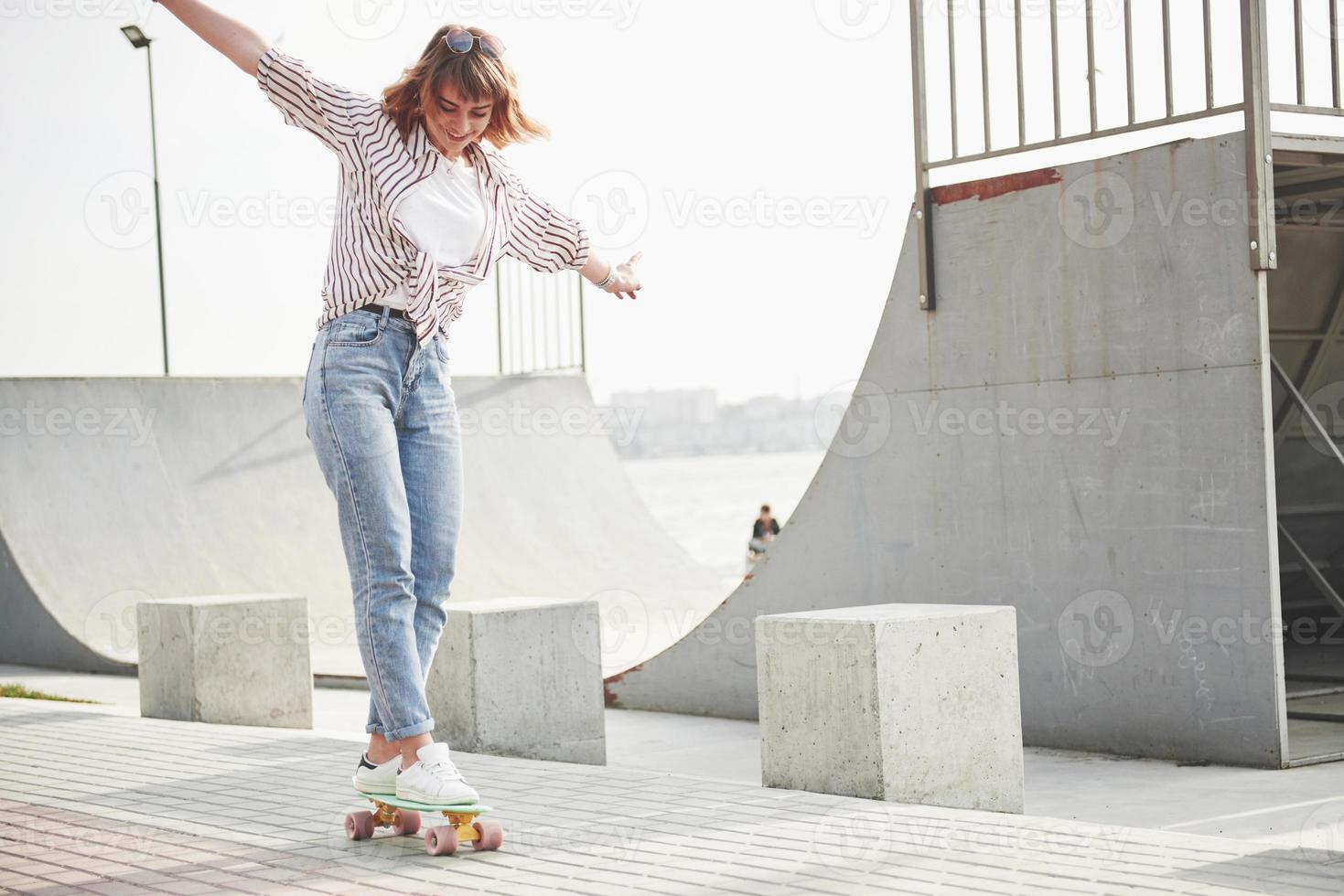 una giovane sportiva che cavalca in un parco su uno skateboard. foto