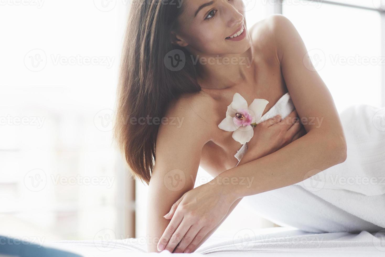 bella donna del corpo con orchidea fiore bianco e cura del corpo. foto