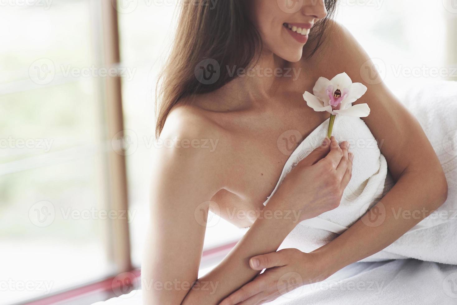 bella donna del corpo con orchidea fiore bianco e cura del corpo. foto