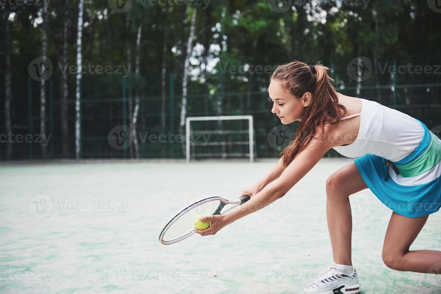 ritratto di un giovane giocatore di tennis in piedi pronto per un servizio. foto