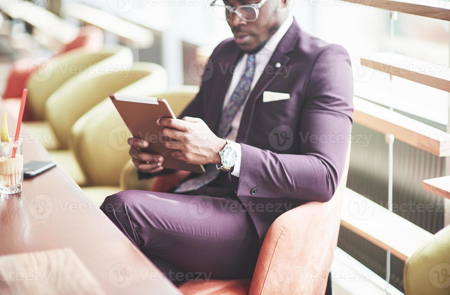 un bellissimo uomo d'affari afroamericano legge in un caffè. foto