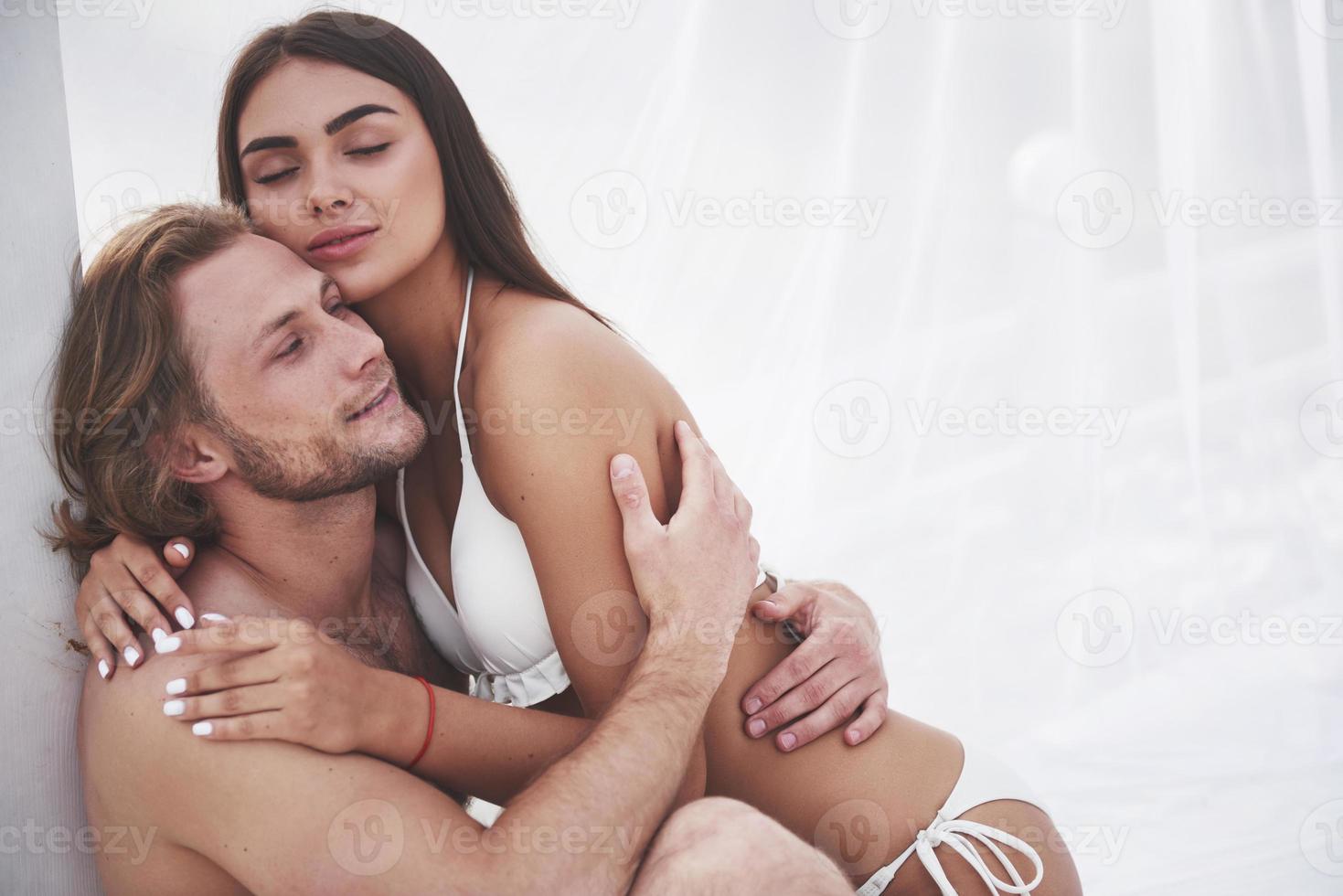 una coppia romantica sulla spiaggia in costume da bagno, bei giovani sexy foto