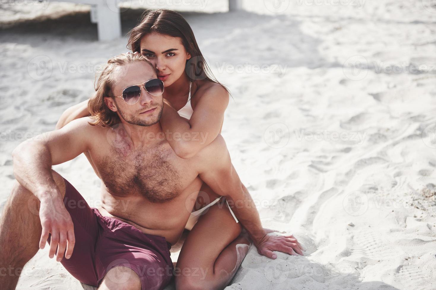 una coppia romantica sulla spiaggia in costume da bagno, bei giovani sexy foto