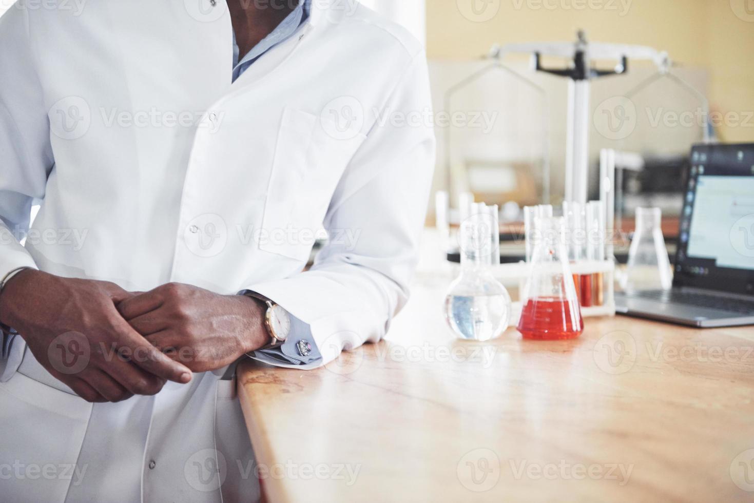 un lavoratore afroamericano lavora in un laboratorio conducendo esperimenti. foto