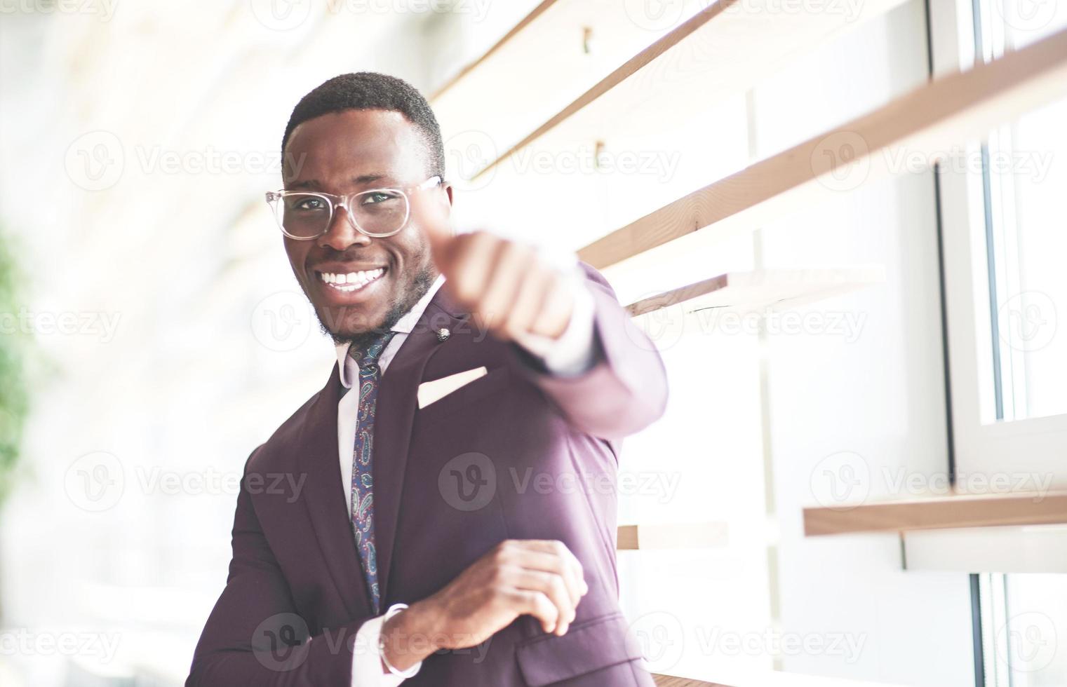 un bellissimo uomo d'affari afroamericano legge in un caffè. foto