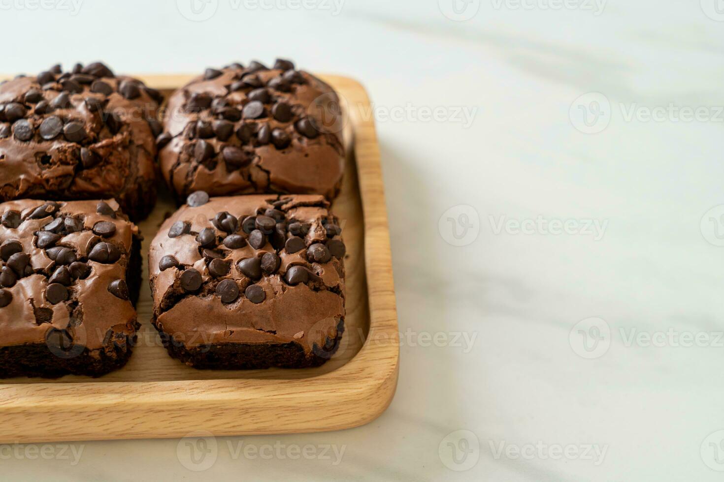 Brownies al cioccolato fondente ricoperti da gocce di cioccolato foto