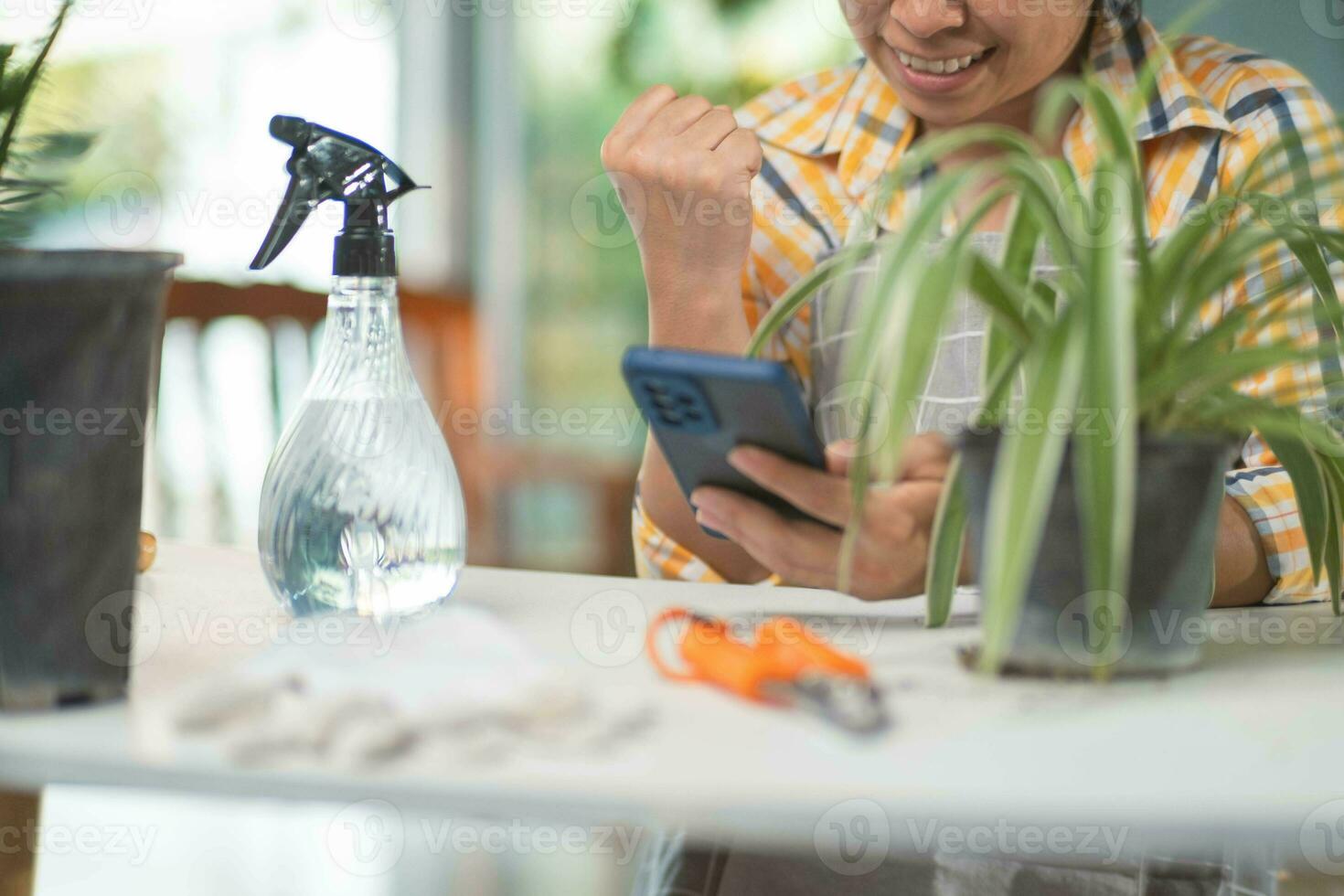 vicino su di giovane femmina giardiniere indossare guanti per cura per in vaso impianti al chiuso. proprietario inizio su piccolo attività commerciale serra. foto