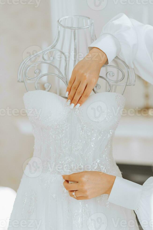nozze vestito su un' manichino, ragazze mani, avvicinamento, su il vestito foto