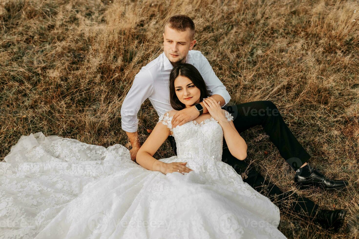 il sposa e sposo siamo dire bugie su il asciutto erba e abbracciare, un' donna nel un' bianca nozze vestire. bellissimo autunno nozze foto. foto