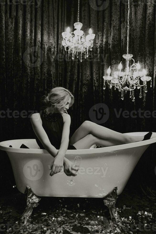 romantico donna dire bugie nel il bagno con Natale i regali e un' bicchiere di Champagne nel sua mano. allegro Natale. nero e bianca foto con artistico rumori