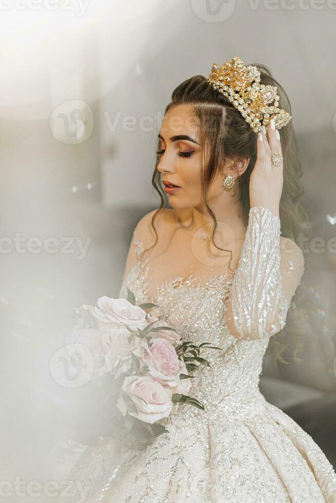 un' giovane Principessa nel un costoso lussuoso vestito con un' dorato tiara su sua testa è in piedi. elegante moda foto