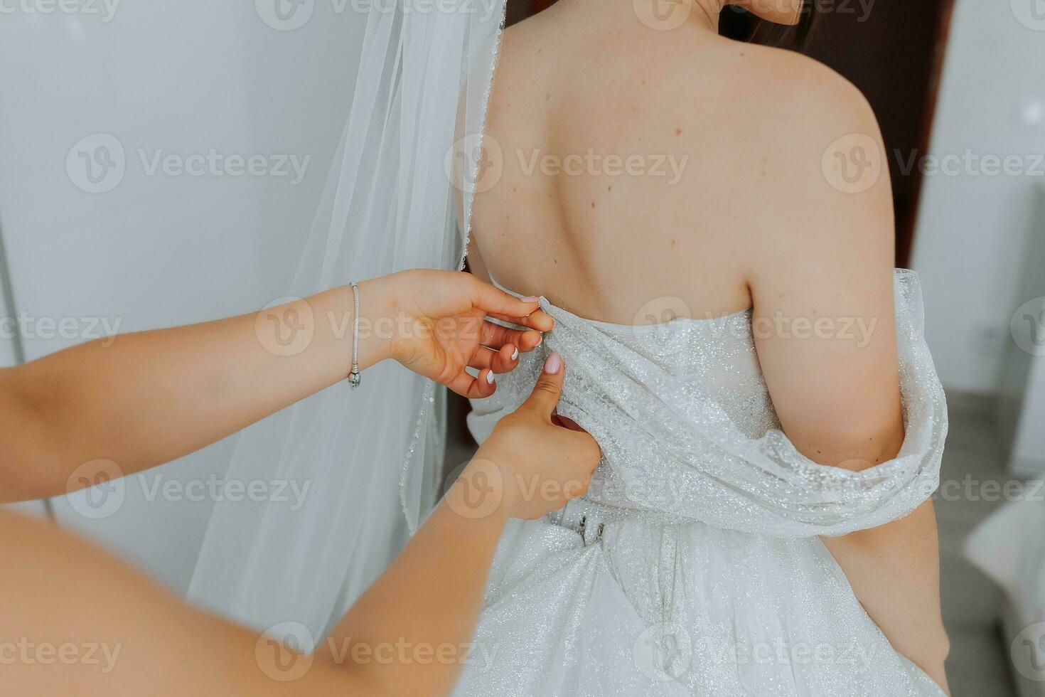 amiche Aiuto il sposa con sua vestire. avvicinamento foto. amiche Aiuto il sposa. foto