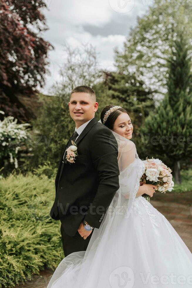 il sposa e sposo In piedi indietro per Indietro. un' coppia di Novelli sposi, sposa e sposo, a un' nozze nel natura, verde foresta, baci, foto ritratto. nozze coppia