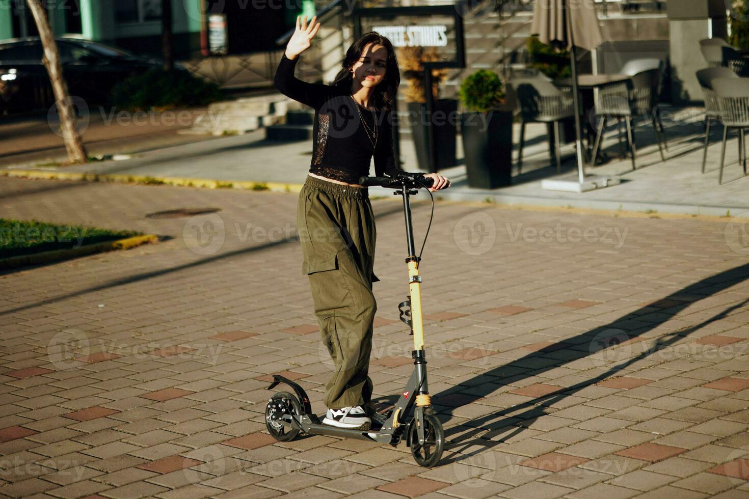 all'aperto ritratto di giovane adolescente brunetta ragazza con lungo capelli guida scooter su città strada foto