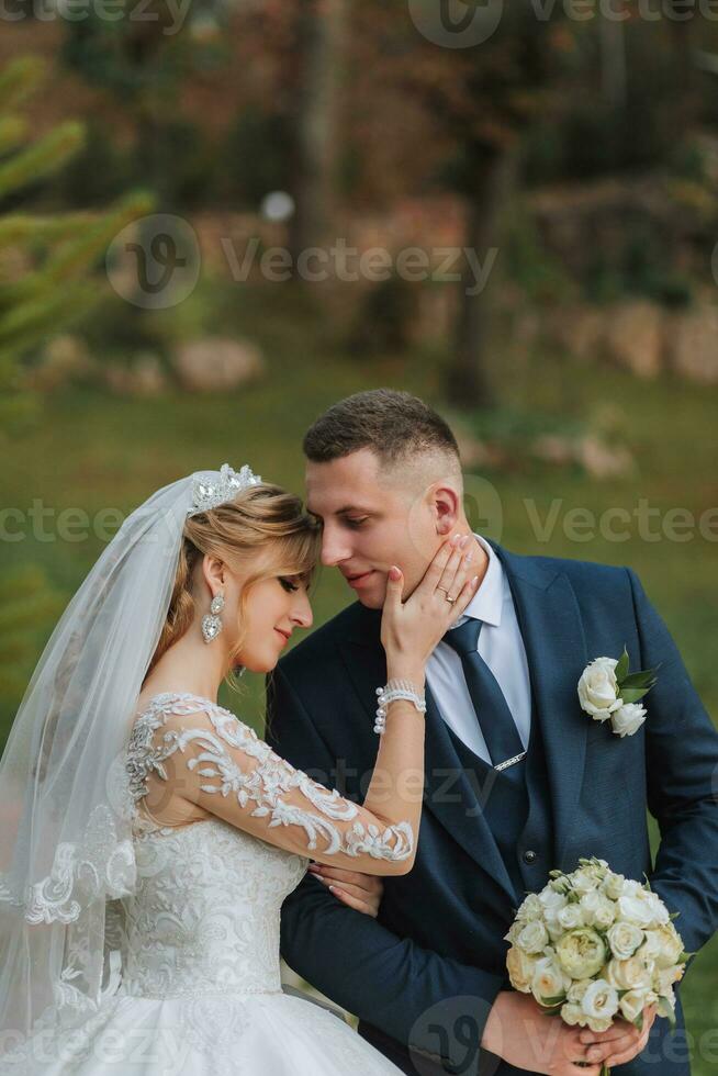 ritratto di un elegante nozze coppia teneramente Abbracciare una persona nel un' foresta o parco. lusso sposa e sposo abbracciando. romantico sensuale momento foto