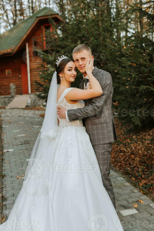 ritratto di il sposa e sposo nel natura, un' bellissimo coppia nel amore. autunno albero le foglie. il Novelli sposi siamo a piedi nel il autunno parco foto