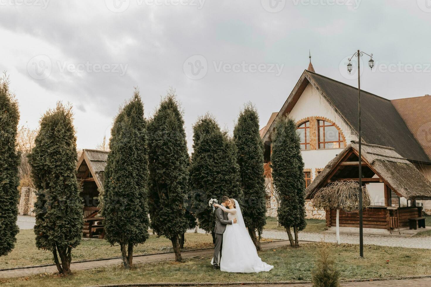 elegante sposa e sposo teneramente abbraccio e bacio. bellissimo sposa con moderno mazzo Abbracciare una persona elegante sposo nel autunno parco. sensuale romantico momento. nozze. elegante e Bellissima. foto