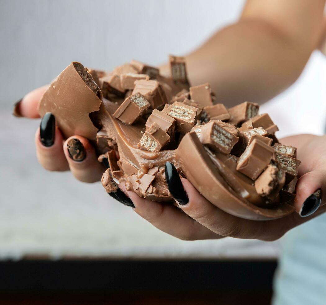 donna di mani Tenere cioccolato trucioli. selettivo messa a fuoco. foto