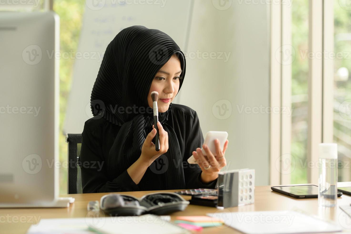 donna d'affari araba che indossa l'hijab lavora in ufficio foto