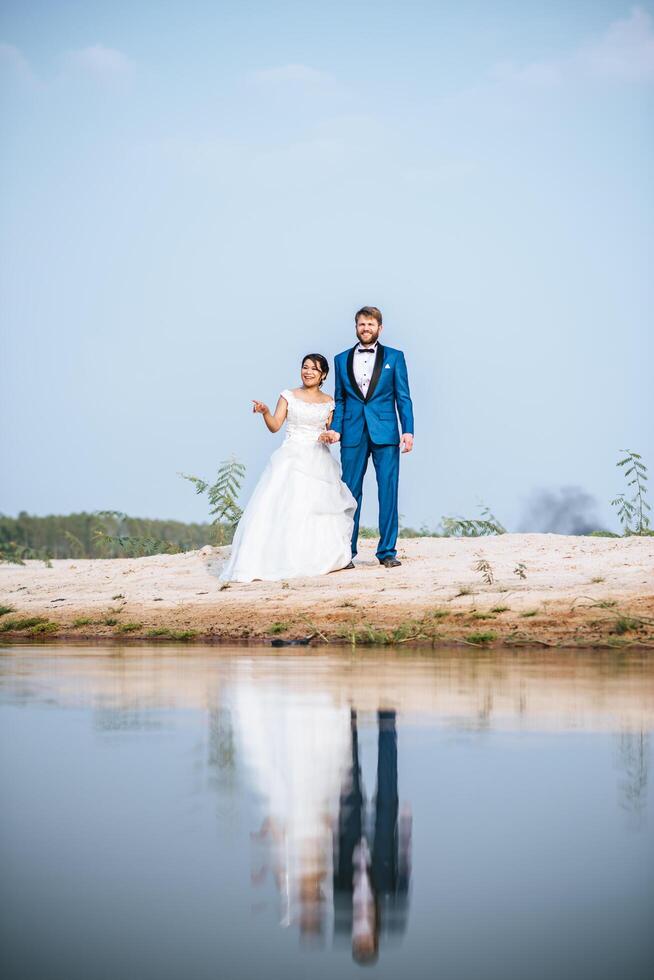 la sposa asiatica e lo sposo caucasico hanno tempo di romanticismo e sono felici insieme foto