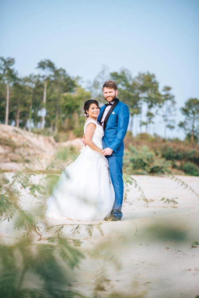 la sposa asiatica e lo sposo caucasico hanno tempo di romanticismo e sono felici insieme foto