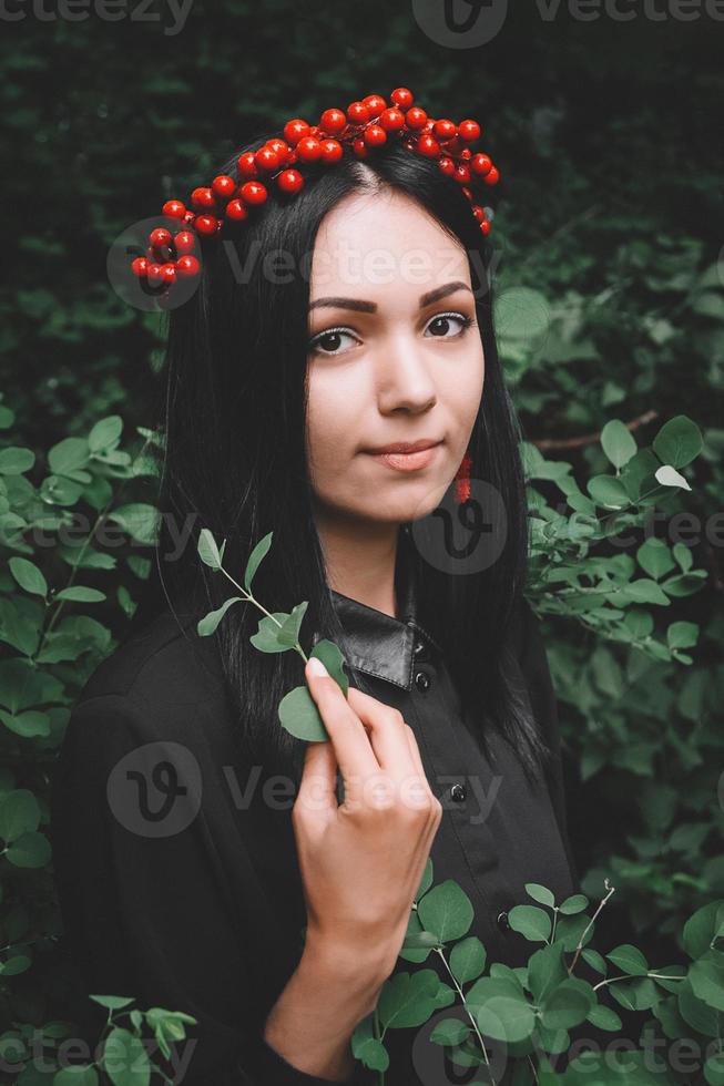 donna in abito nero e decorazioni rosse sullo sfondo della foresta foto