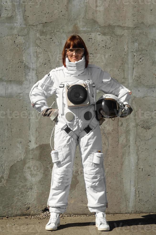 astronauta donna senza casco sullo sfondo di un muro grigio foto