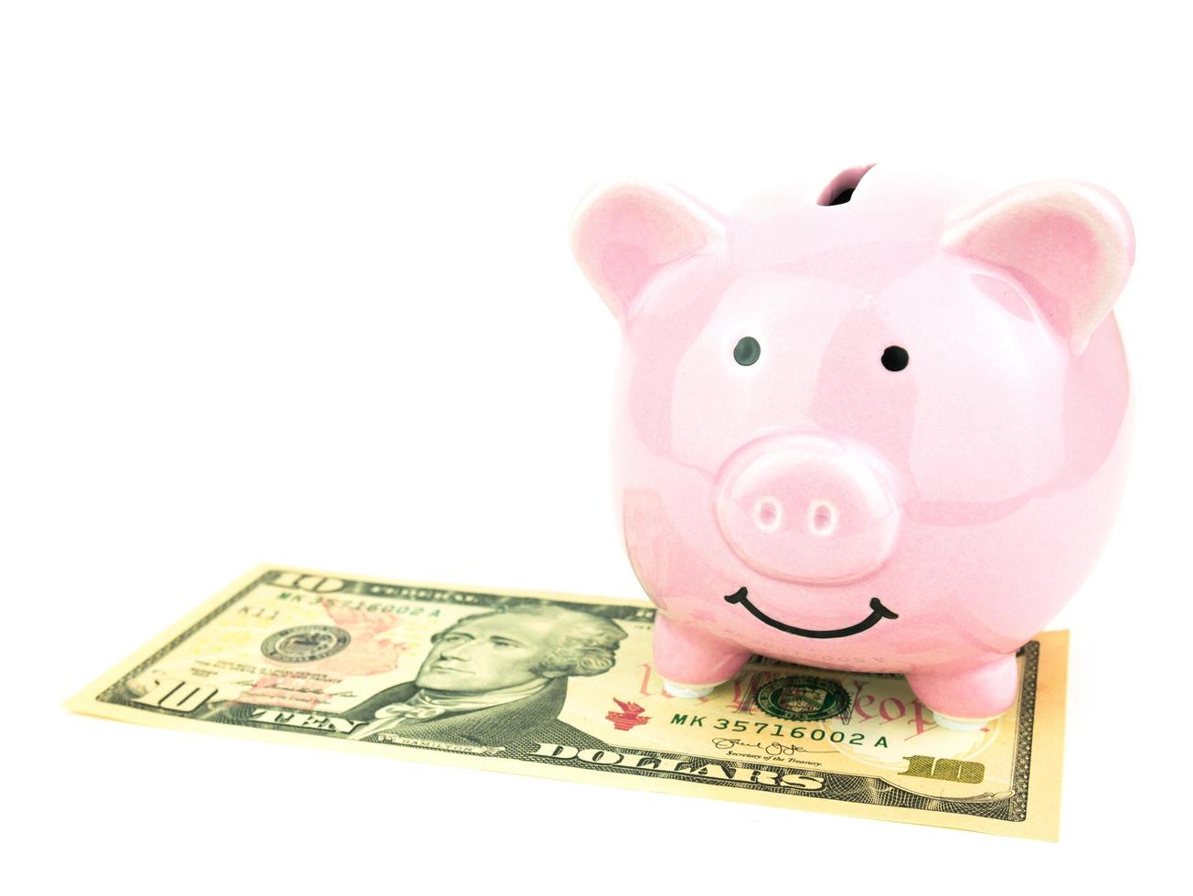salvadanaio rosa su dollari banconota isolati su sfondo bianco, concetto di risparmio foto