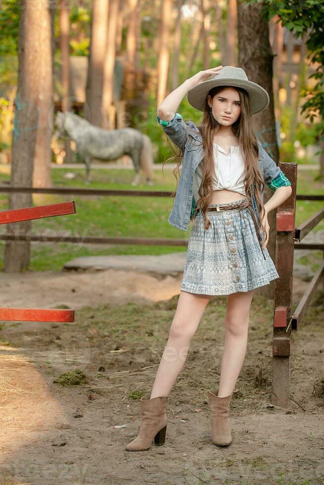 adolescenziale azienda agricola ragazza in piedi vicino all'aperto stabile nel nazione tenuta foto