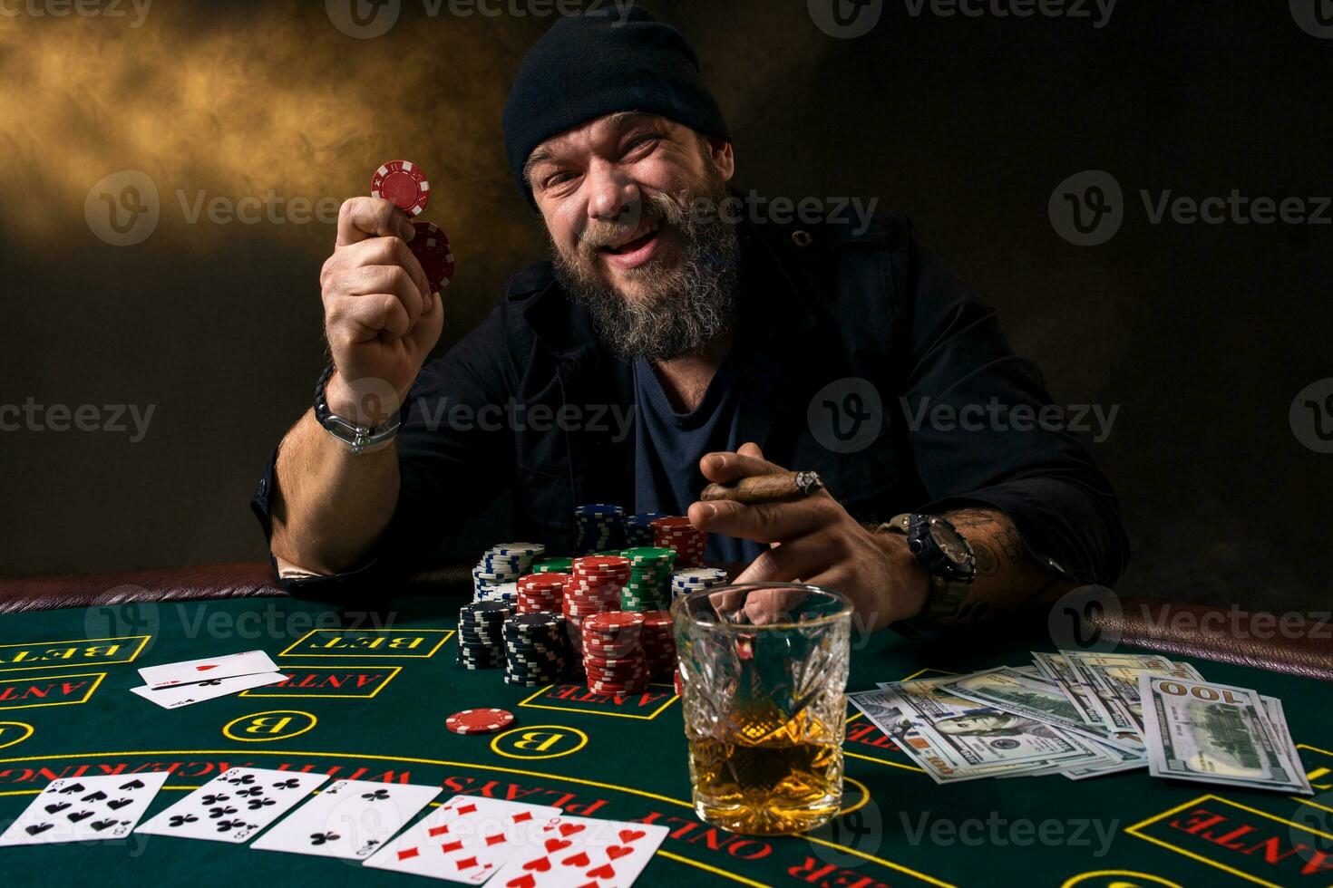 barbuto uomo con sigaro e bicchiere seduta a poker tavolo nel un' casinò. gioco d'azzardo, giocando carte e roulette. foto