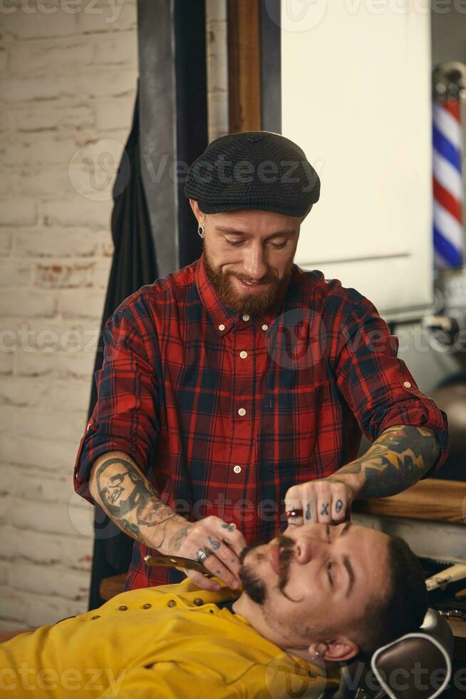 cliente durante barba rasatura nel barbiere negozio foto