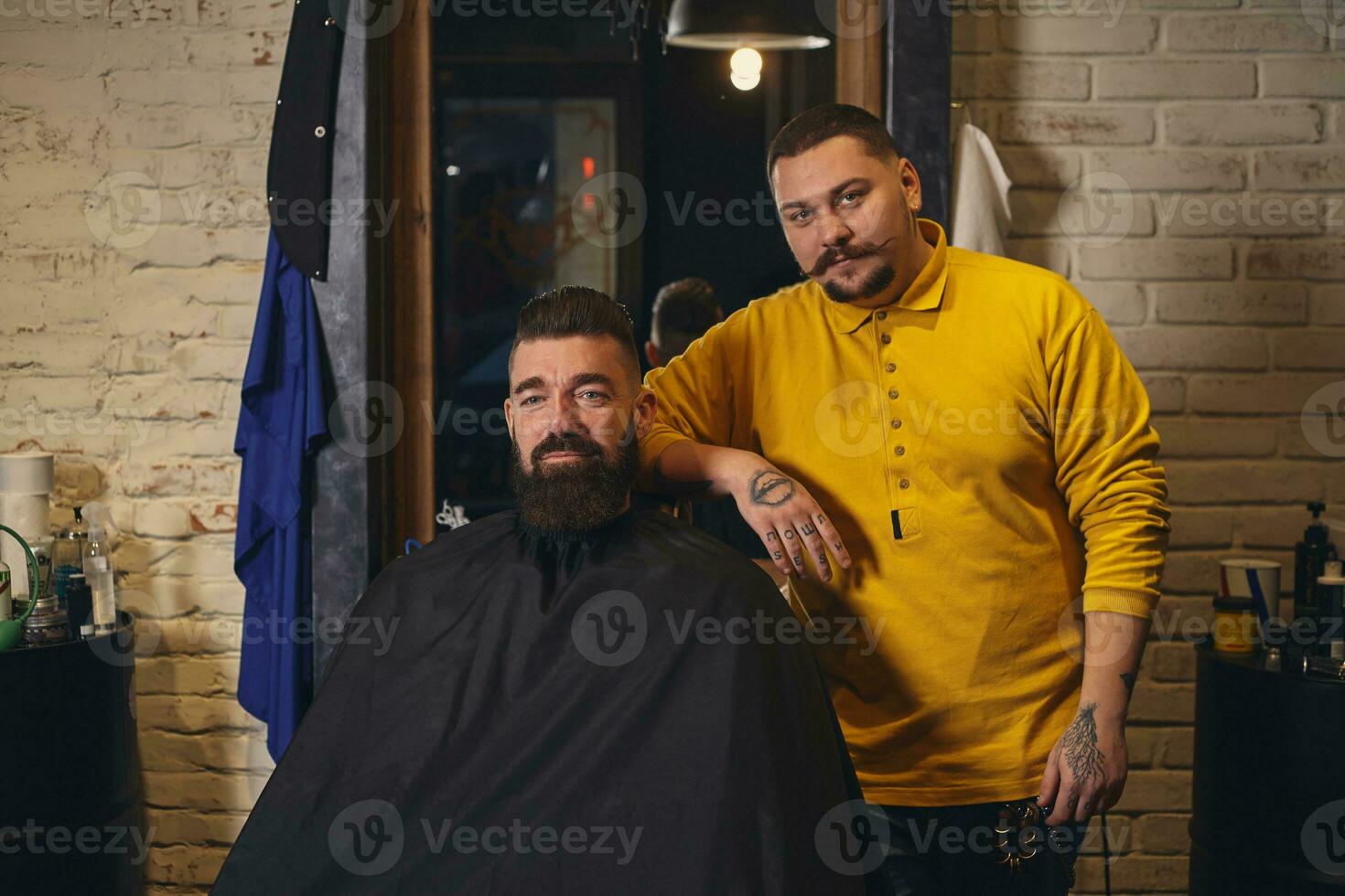 cliente con grande nero barba durante barba rasatura nel barbiere negozio foto