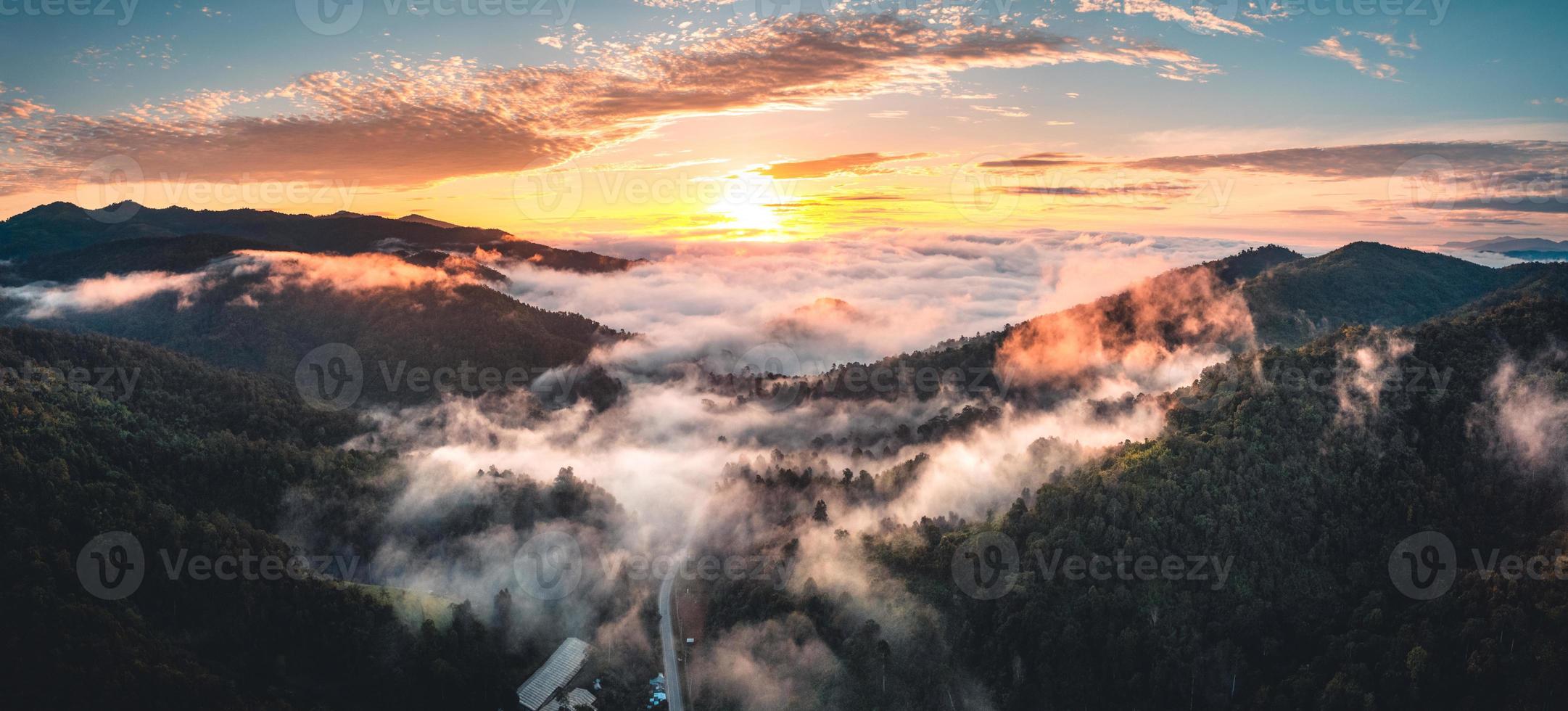 il sole sorge nella nebbia e nelle montagne al mattino foto