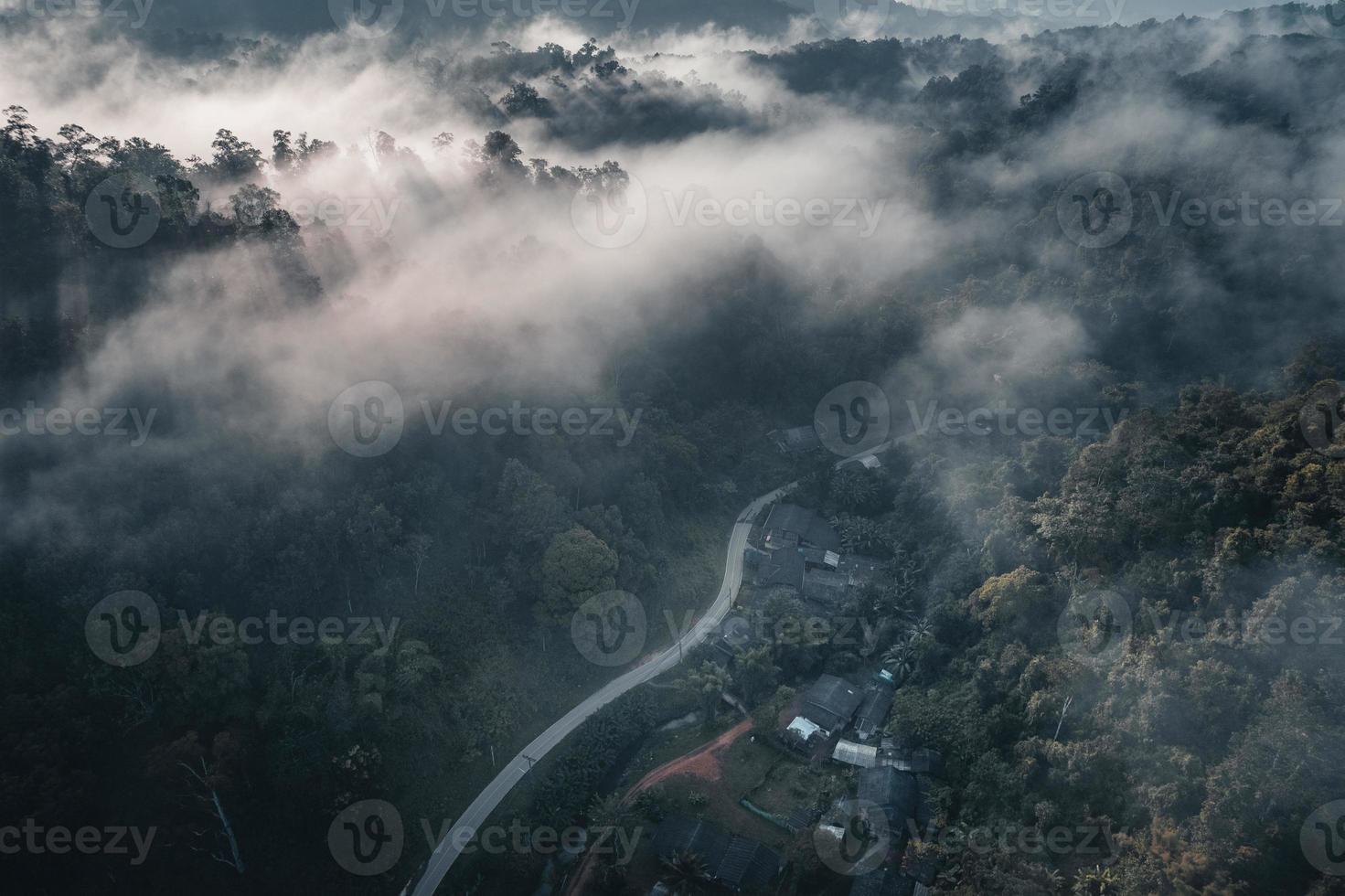 il sole sorge nella nebbia e nelle montagne al mattino foto