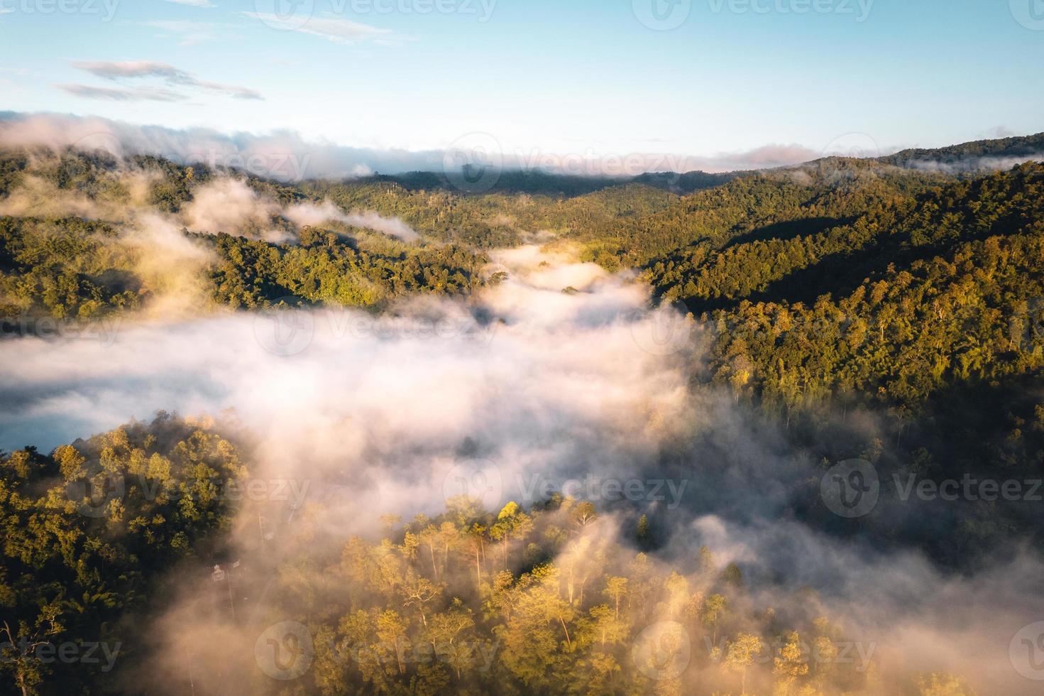 il sole sorge nella nebbia e nelle montagne al mattino foto