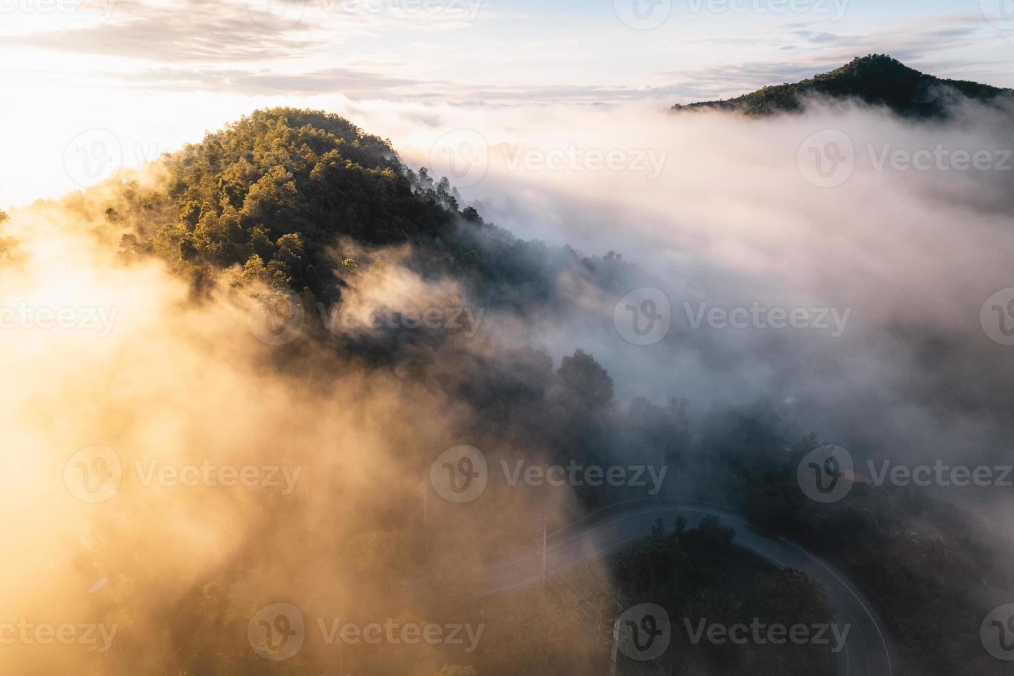 il sole sorge nella nebbia e nelle montagne al mattino foto