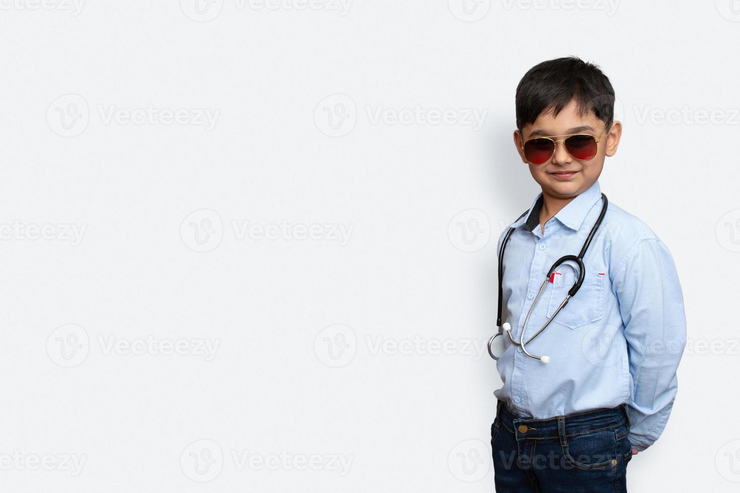 Sorridente ragazzino con stetoscopio e occhiali sfondo isolato con copia space foto