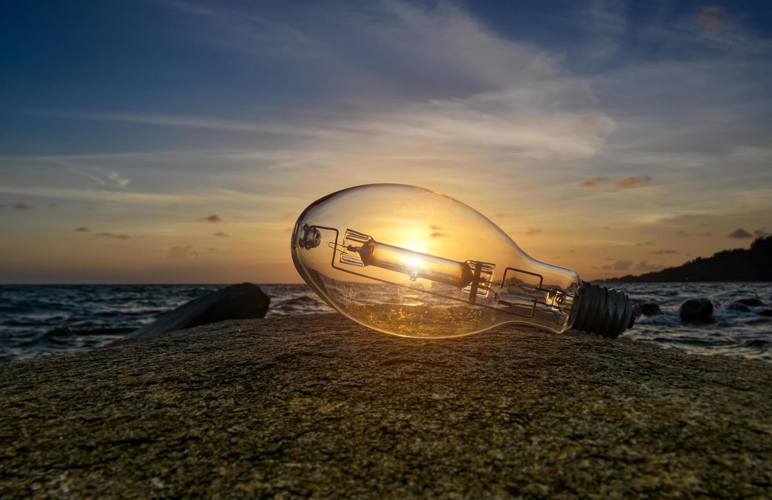 spazzatura lampadina sulla spiaggia con la luce del sole. foto