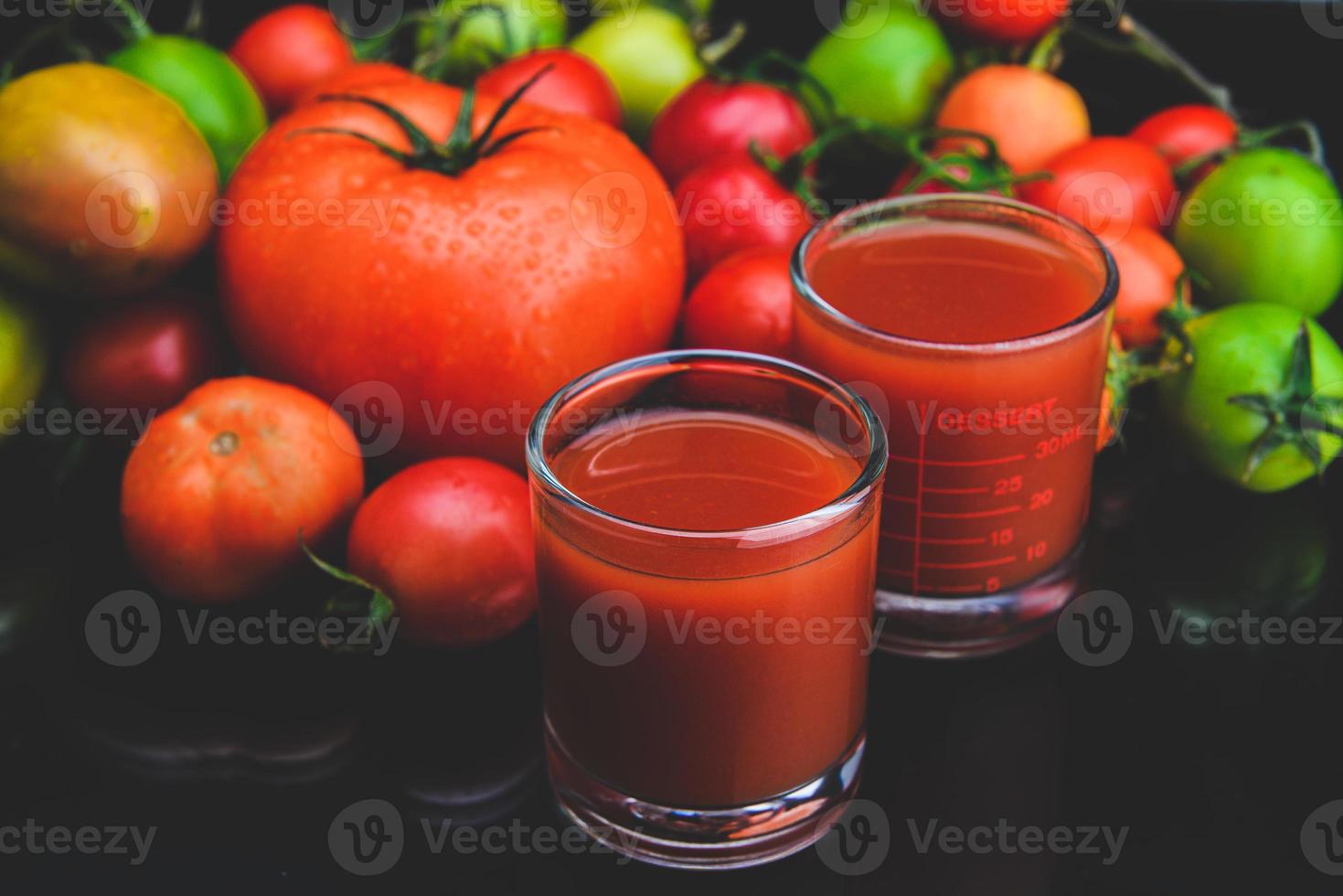 mescolare pomodori e succhi in un bicchiere. foto