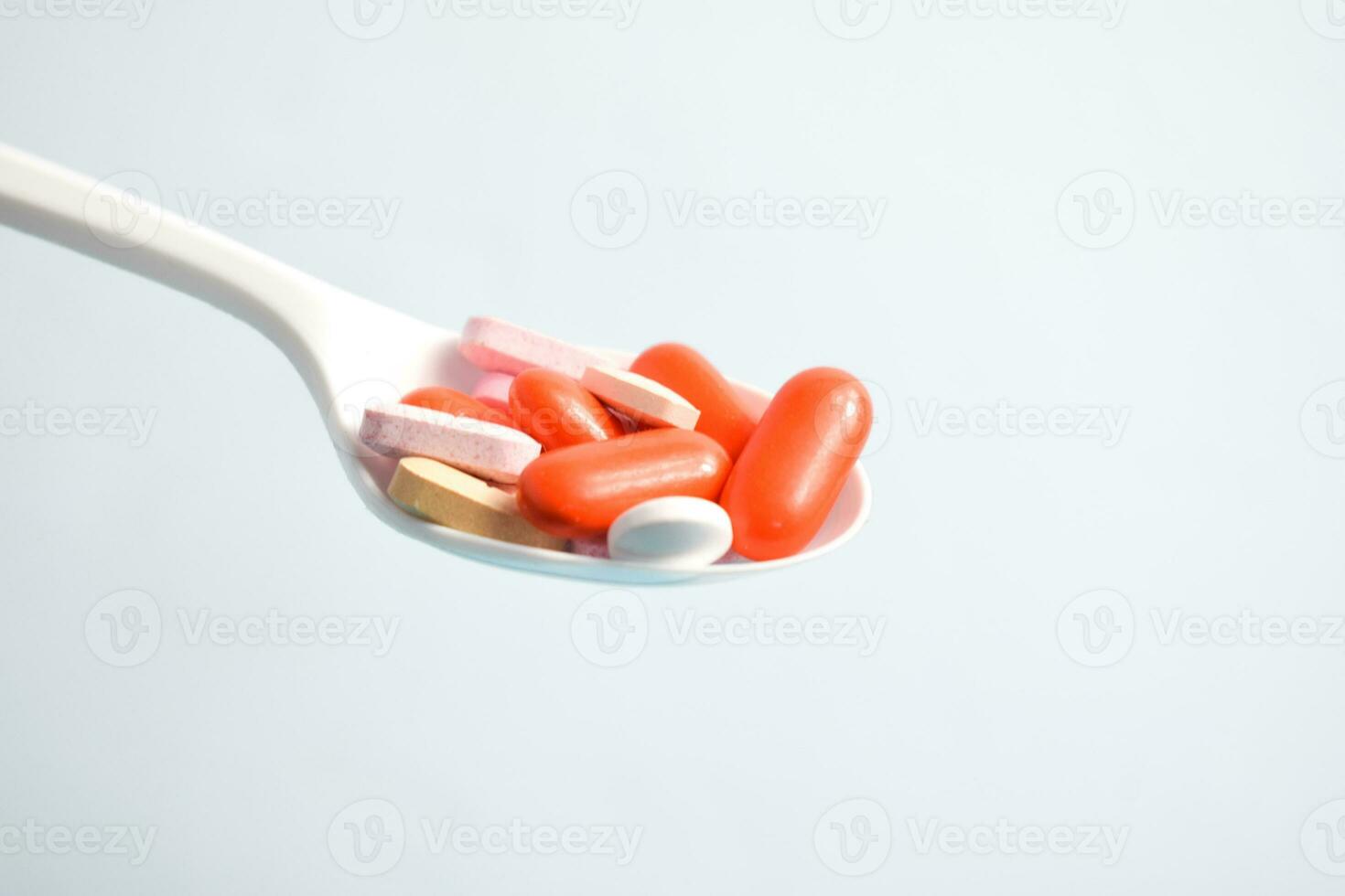 colorato medicina pillole nel bianca cucchiaio su bianca sfondo, supplemento, vitamina, colorato foto
