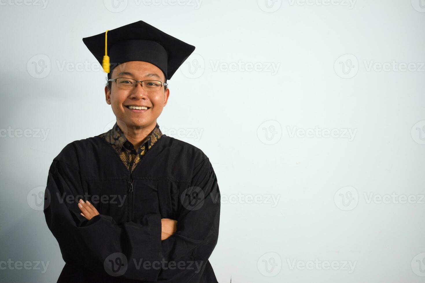 espressive di adulto Indonesia maschio indossare la laurea veste, cappello e occhiali isolato su bianca sfondo, espressioni di ritratto la laurea foto