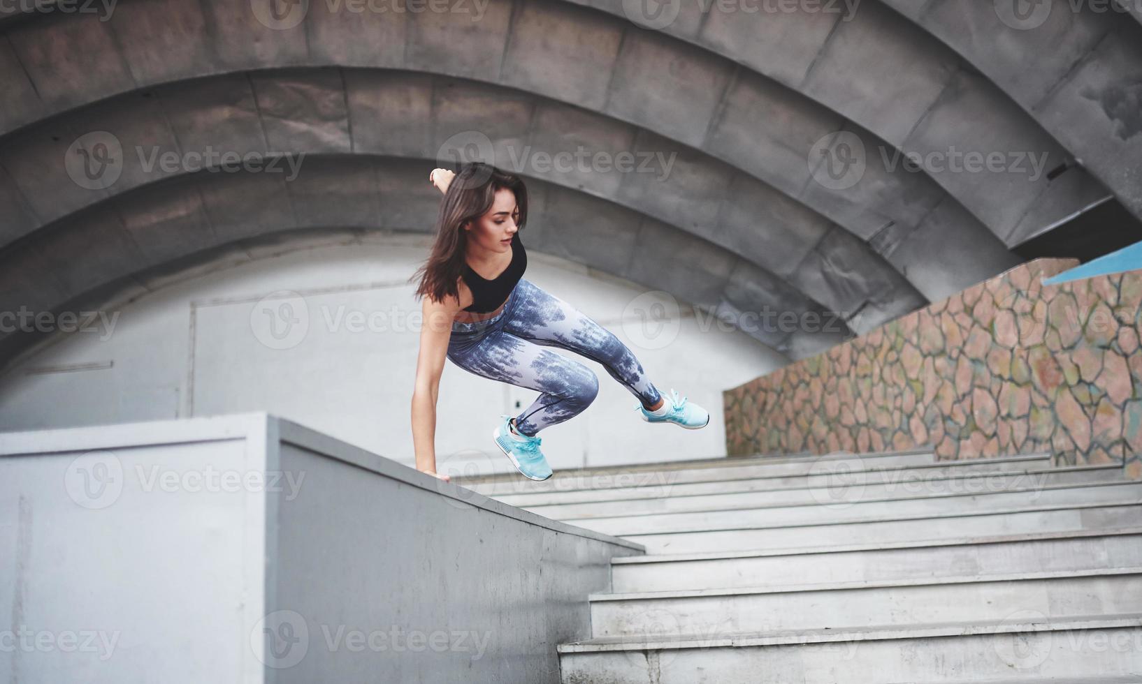 donna che fa parkour in città in una giornata di sole foto